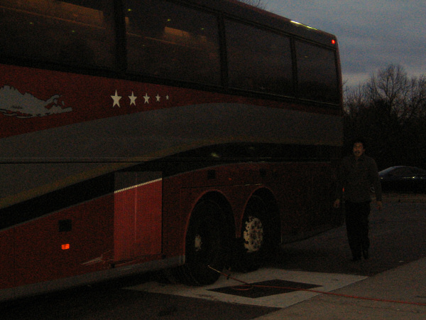 The bus driver adjusting the pressure in the tire.